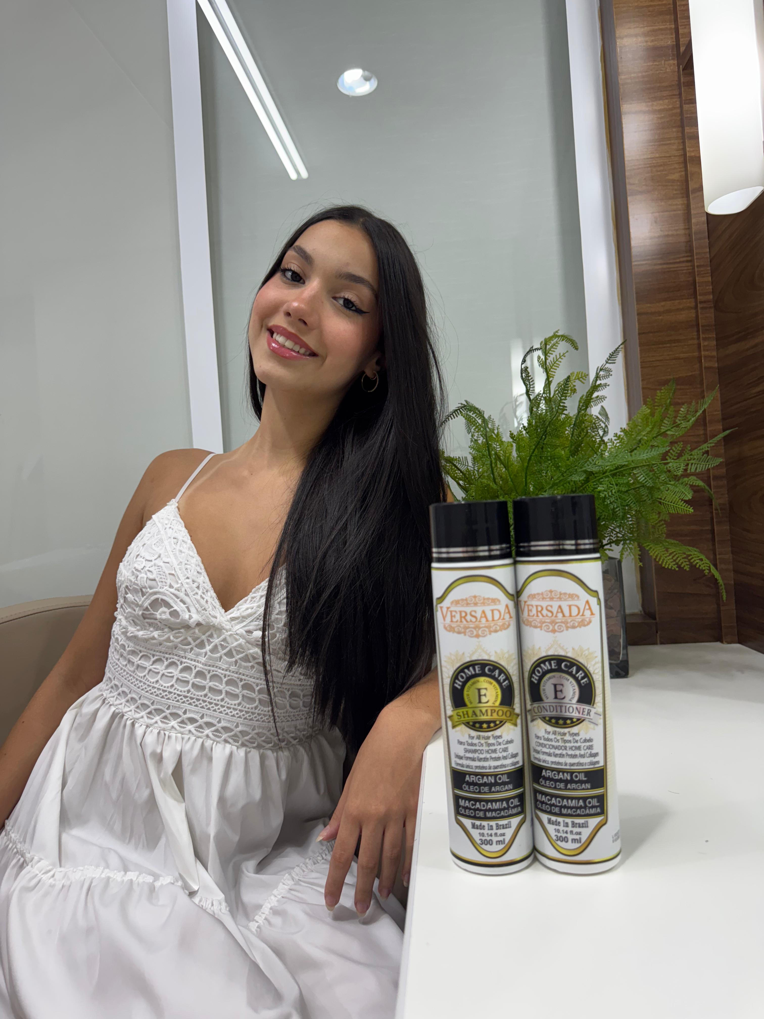 Woman in a white dress sitting next to two bottles of Versada hair care products.